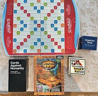 Group shot showing Scrabble board, Cards Against Humanity box, Survivor box, Overrated/Underrated box, American Trivia box