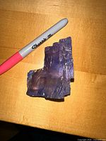 Front view of blue halite next to Sharpie for scale