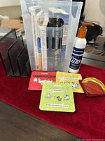 Overview of lot showing bin with books, letter sorter, coasters, acrylic paperweight, and MAAS polish bottle