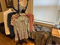 Group of shirts on hanger and folded pants