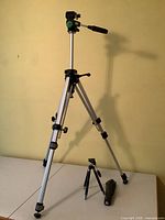 Full view of full-size tripod extended with mini tripod and carry case at its base