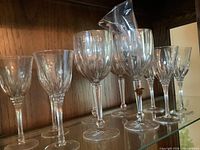 Group of ten crystal wine glasses in cabinet