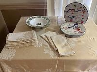 Overview showing bowls, plates and two stacks of linens on table