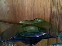 Top view of hand-blown blue green bowl showing wavy rim and color gradient