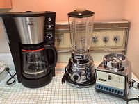 Coffee maker and two blender units on counter