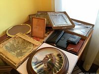 Assorted frames, wallets and plates on table