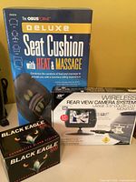 Group shot of all four boxed items: ObusForme cushion, wireless camera kit, two Black Eagle 3000 boxes