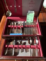 Open wooden flatware chest showing full 1881 Rogers service including knives, forks, spoons and serving pieces