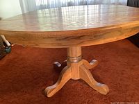 Side view of solid oak pedestal table on carpet
