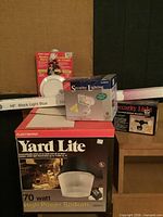 Group shot of Yard Lite sodium fixture box, Security Lighting boxes, smoke detector package, and black-light tube