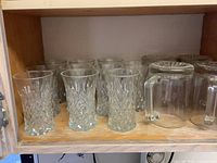 Beer mugs and cut glass tumblers on shelf