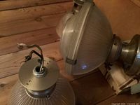 Top view of two fixtures showing wiring, metal canopy and glass shade