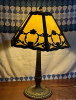 Full view of lit slag glass lamp showing shade and base