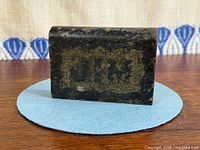 Rear view displaying rectangular recessed panel with faint initials