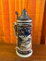 Full view of beer stein front with deer relief and pewter lid