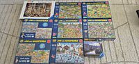 All nine puzzle boxes laid out: Ravensburger 5000 pc plus eight Jan van Haasteren 1000 pc boxes including one double pack