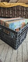 Stack of LPs in black plastic crate, spines visible