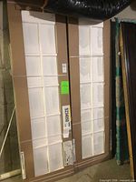 Both factory-wrapped French doors side by side showing glass lites and packaging