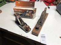 Both planes side by side on workbench with Buck Bros box