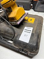 Palm sander resting on DeWalt hard case
