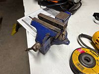 Blue swivel-base bench vise on workbench