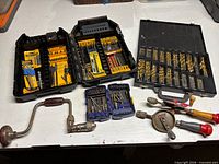 Overview of all bit sets, brace drill and two geared hand drills on table