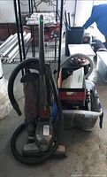 Front angled view of Kirby upright vacuum with hose attached and accessory tote beside