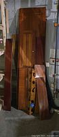 tall stack of mahogany doors, panels & slats leaning against wall