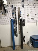 Overall view of levels, cases and brackets on pegboard wall