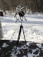 Full view of armillary sphere on tripod in outdoor setting