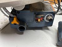 Close-up of scroll saw control panel showing on/off switch, speed dial, dust port