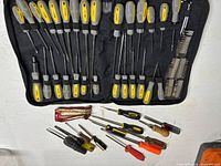 Full WorkForce screwdriver set in canvas bag with assorted loose screwdrivers beneath