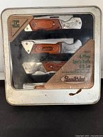 Front view of closed tin showing product information and rust spot