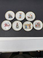 Seven miniature plates front view displaying different Hummel illustrations
