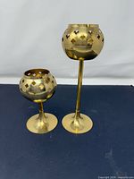 Tall and short brass goblet candle holders side by side