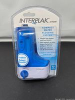 Front view of sealed Interplak by Conair compact water flossing system package