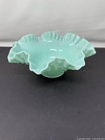 Angled view showing pastel green bowl with ruffled rim and hobnail texture
