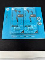 Front view of two sealed JLab Audio JBuds Elite Bluetooth earbuds on retail card