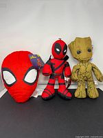 Group view of three Marvel plush toys: Spider-Man pillow, Deadpool, Groot