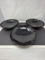 Three black Mikasa bowls showing interior scroll design