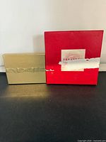 Michael Kors gold box and Tommy Hilfiger red box side by side