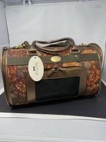 Overall view of floral tapestry cylindrical pet carrier with hang tag