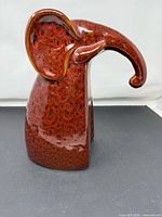 Left side view of red ceramic elephant figurine