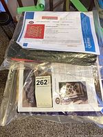 Two quilt kits sealed in plastic bags with instruction sheets visible