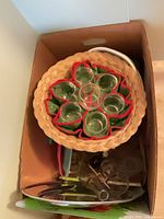 Box top with woven basket holding six glass shot glasses and visible extension cord