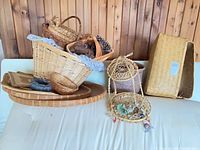 Group of assorted baskets, tray, mat on sofa