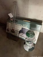 Stove box, lantern wrapped in plastic, BBQ basket leaning