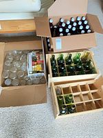 Group showing plastic beer bottles, canning jars, wine bottles in wooden crates