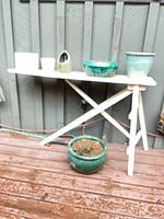 Overall view of wooden ironing board with multiple ceramic planters displayed