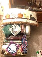Top view of boxes showing patchwork body pillow, stacks of blankets and cushions